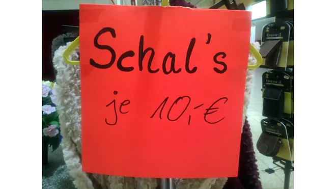 Das Bild zeigt ein Verkaufsschild, auf dem das Wort Schals fälschlicherweise mit einem Deppenapostroph geschrieben ist.